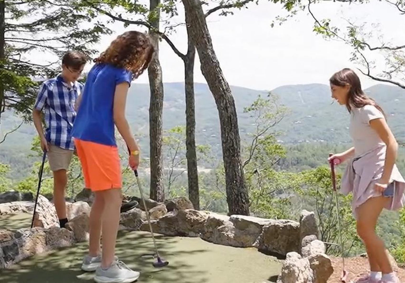 Friends enjoying mini-golf outdoors.